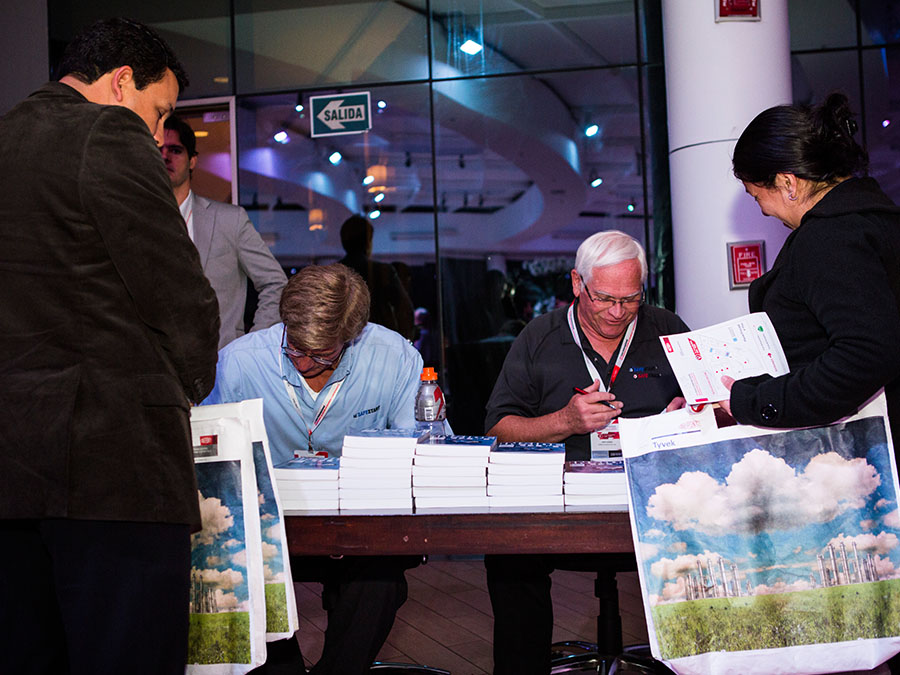 Larry Wilson and Gary A. Higbee sign their book Inside Out at a DuPont forum in Lima, Peru