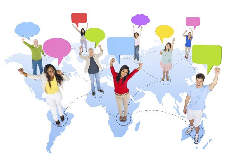 Multicultural people standing on a graphic of the earth's continents, arms raised, with empty speech bubbles floating above their heads
