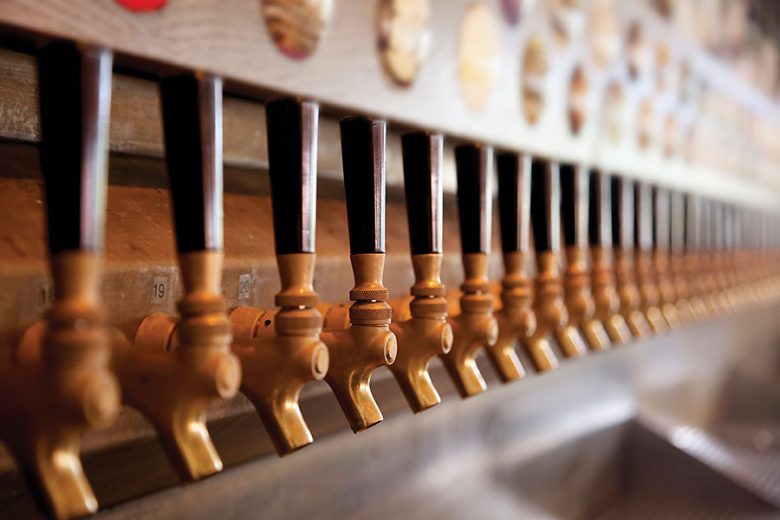A row of beer spouts are prepared to pour Heineken