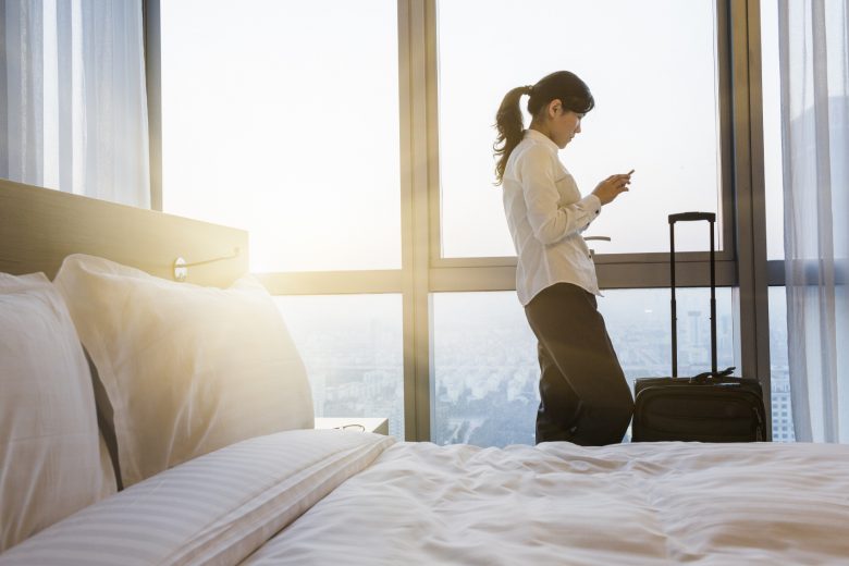 A woman uses her phone in a hotel room while at a safety conference