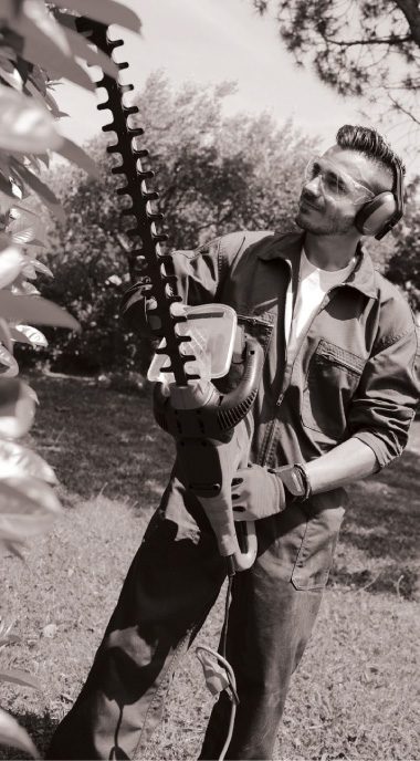 A man operating a hedge trimmer