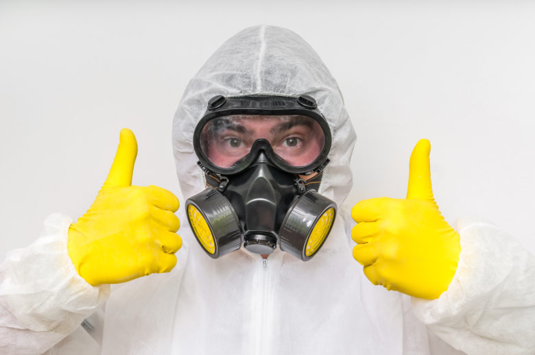 Man in hazmat suit giving a thumbs up to his respirator