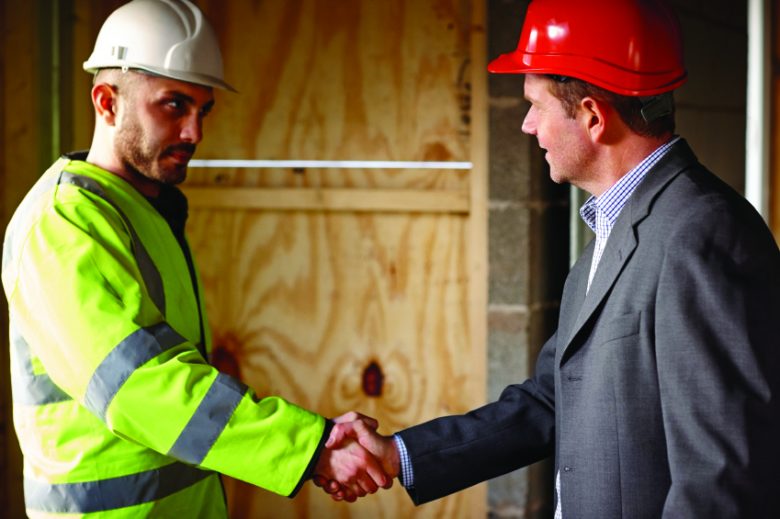 Two constructions workers shaking hands