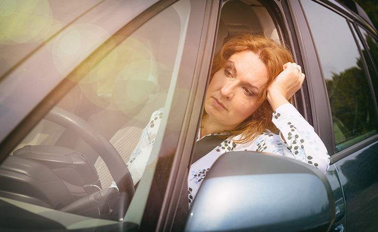Fatigued woman behind the wheel of a car