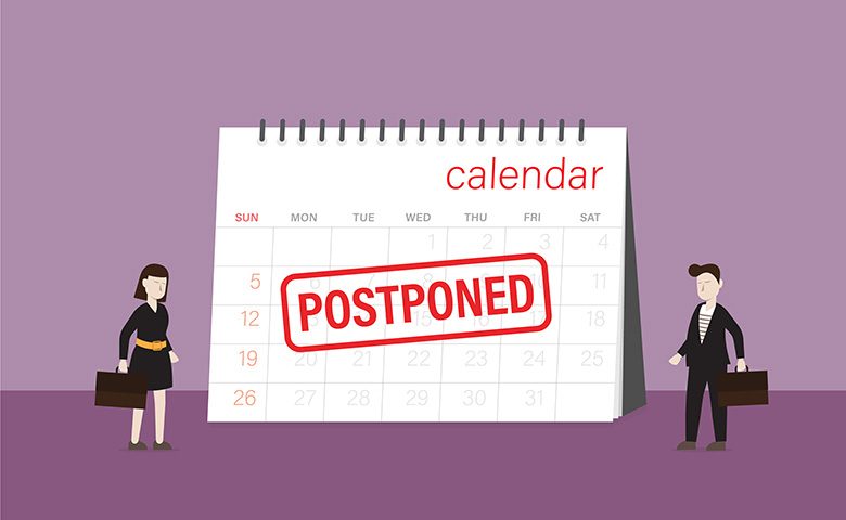 Business people look a postponed rubber stamp on a calendar
