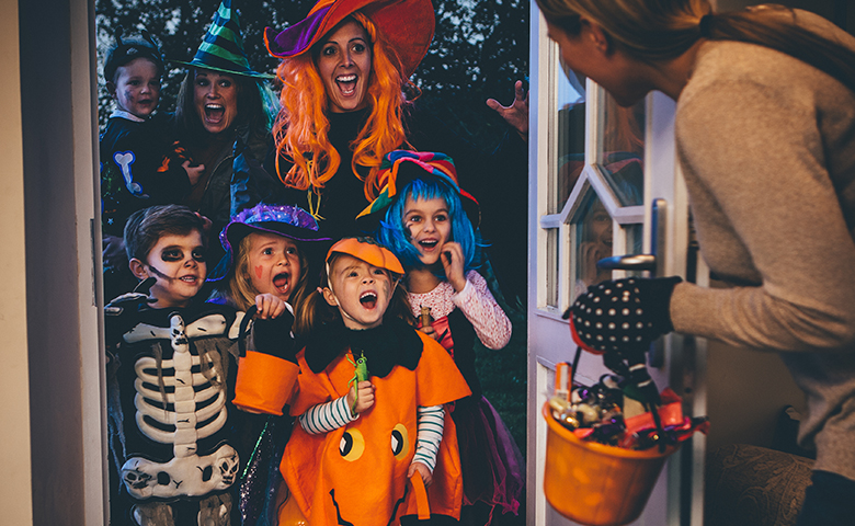 Children trick-or-treating with their parents