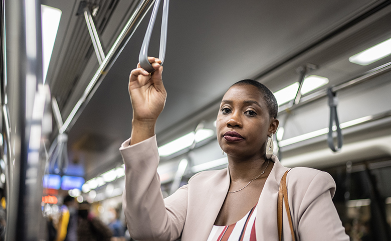 Tired woman holding the handgrip on the subway train