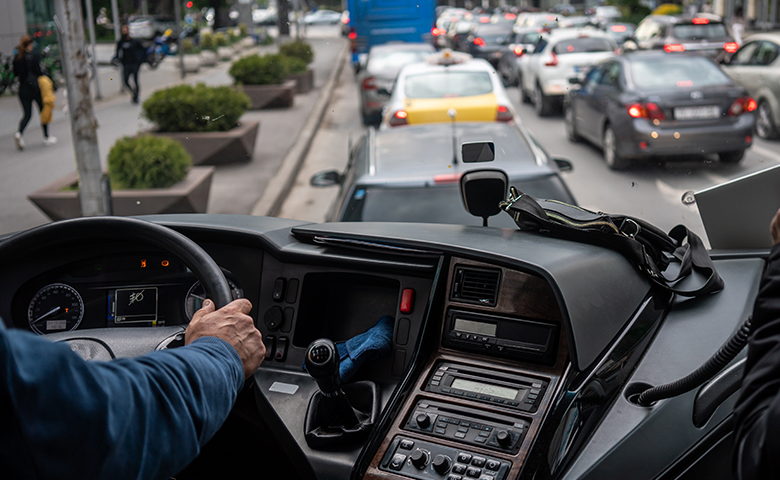 Bus driver holding steering wheel rap is talking close up on hands horizontal bus cockpit photo