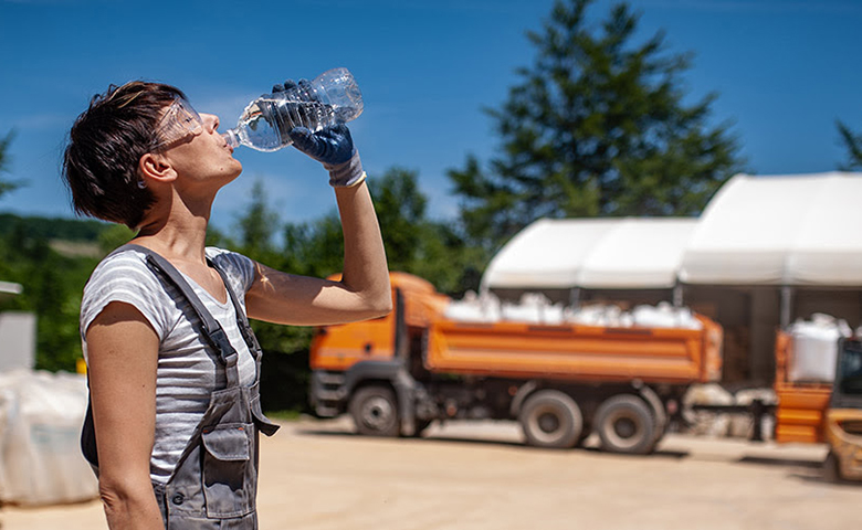 Thirsty Female Blue-collar Worker working on a hot summer day