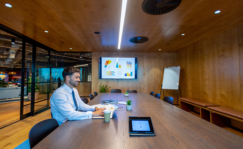 Business man in a room with digital display board