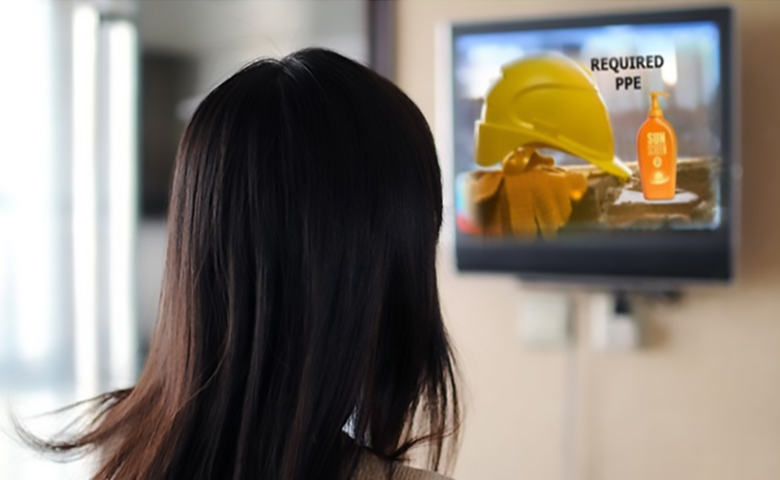 Woman watching a presentation on a TV at work about sunscreen PPE