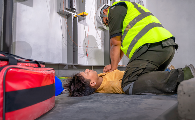 Worker suffered an electric shock accident unconscious, safety team member performs CPR for first aid.