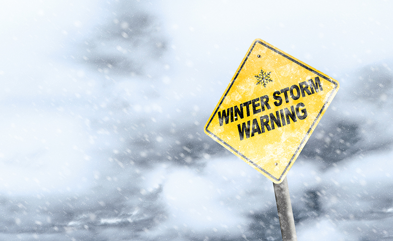 Winter Storm Warning Sign With Snowfall and Stormy Background