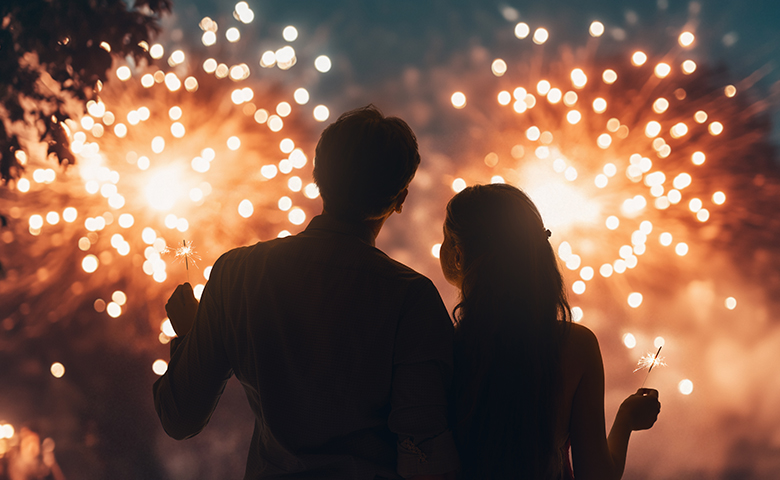Couple watching fireworks holding sparklers