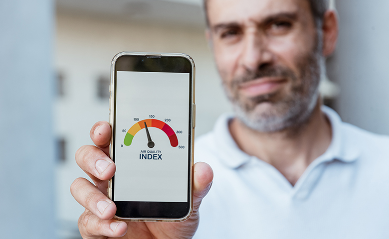 Man check air quality index AQI urban environment on phone outside